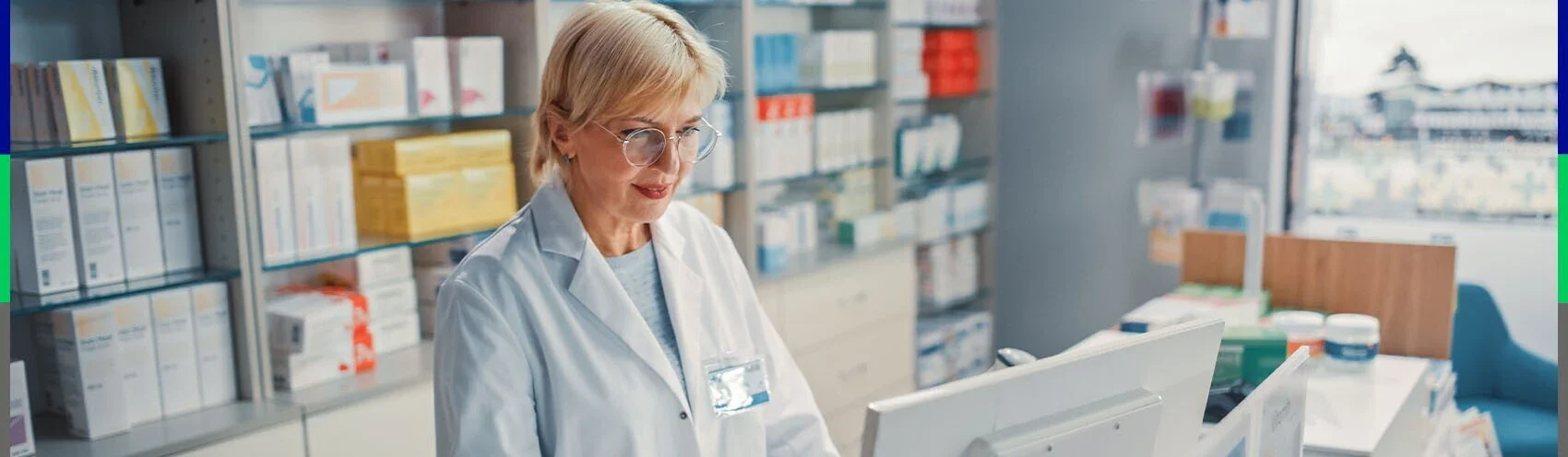 Farmaceuta stoi przed ladą z komputerem