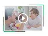 Opiekun karmi małe dziecko z łyżeczki pod czujną obserwacją ich psa