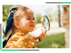 Mała dziewczynka patrzy przez szkło powiększające