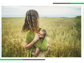 Mama trzyma dziecko w chuście.