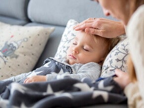 Dziecko z gorączką, mama sprawdza jego temperaturę