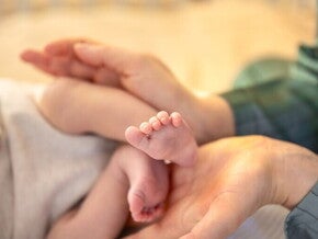 Małe nóżki dziecka w dłoniach mamy