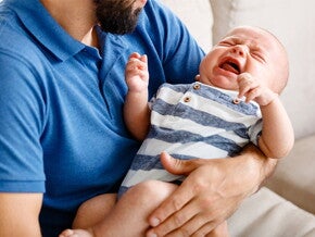 płaczące niemowlę u taty na rękach