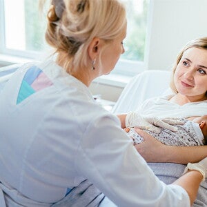 dziecko na rękach mamy oraz lekarz badający dziecko