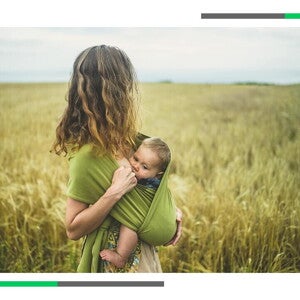 Mama trzyma dziecko w chuście.