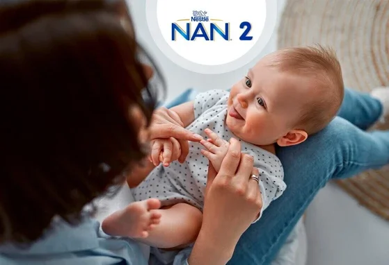 Niemowle siedzące na kolanach mamy