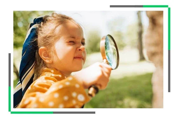 Mała dziewczynka patrzy przez szkło powiększające