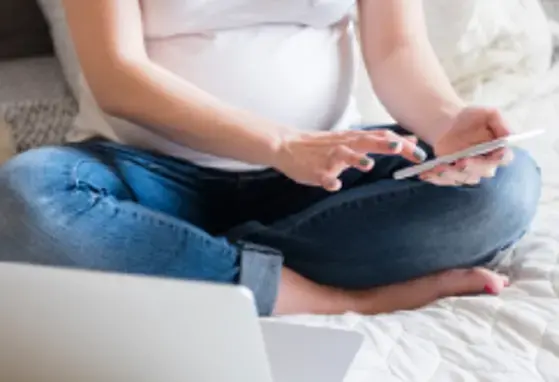 Kobieta w ciąży trzymająca telefon