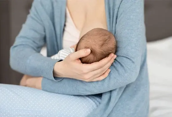 Laktacja po cesarskim cięciu – jak naturalnie wspierać karmienie piersią? dziecko karmione piersią na rękach mamy