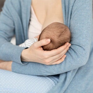 dziecko karmione piersią na rękach mamy