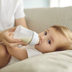 dziecko karmione z butelki przez opiekuna