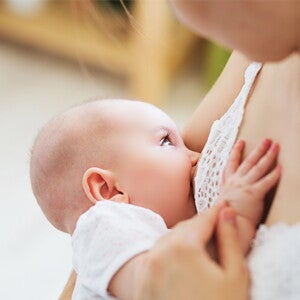 dziecko na rękach u mamy w trakcie karmienia piersią