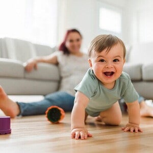 uśmiechnięte raczkujące dziecko na podłodze 