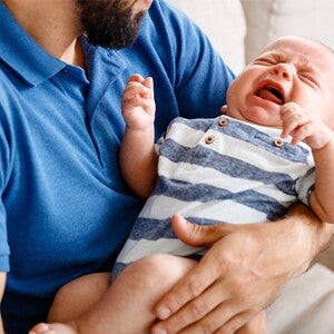 płaczące niemowlę u taty na rękach