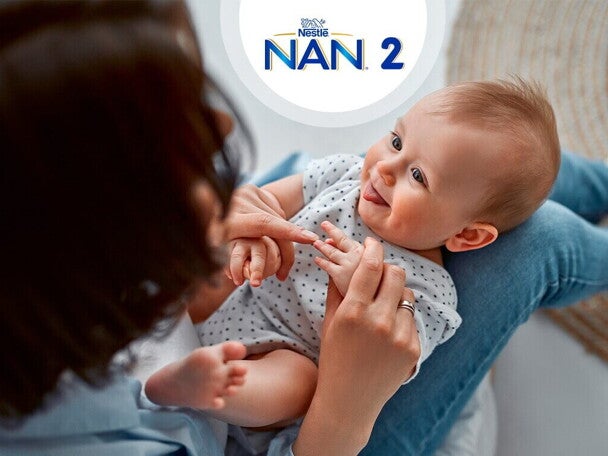 Niemowle siedzące na kolanach mamy