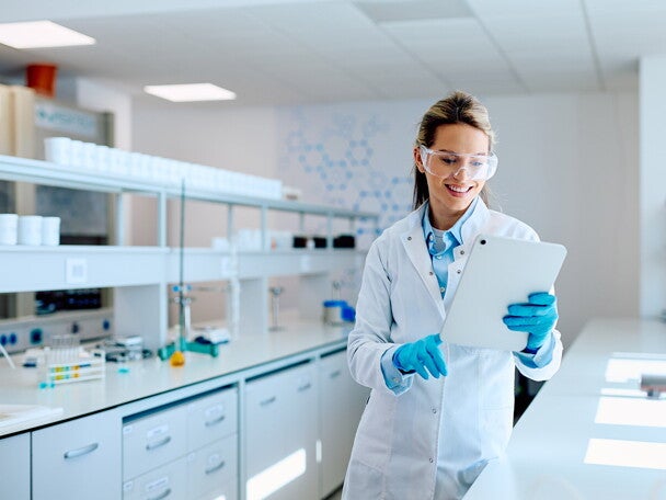 Naukowczyni w okularach ochronnych stoi w nowoczesnym laboratorium medycznym