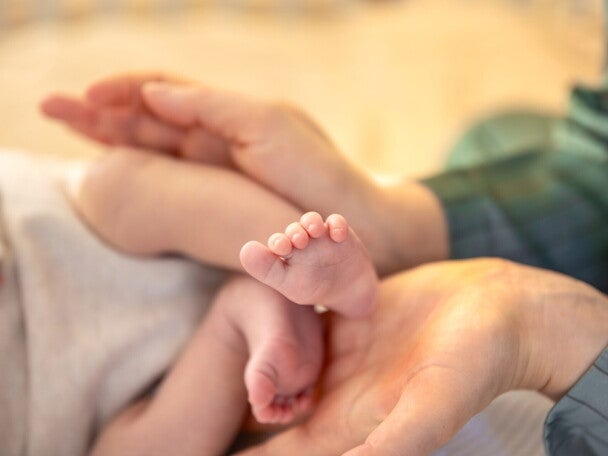 Małe nóżki dziecka w dłoniach mamy
