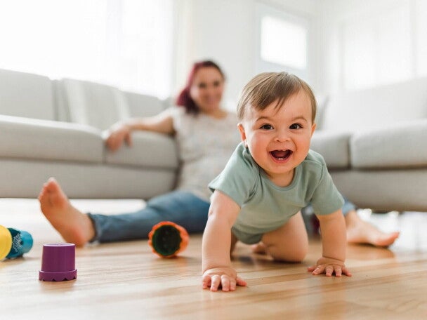 uśmiechnięte raczkujące dziecko na podłodze 