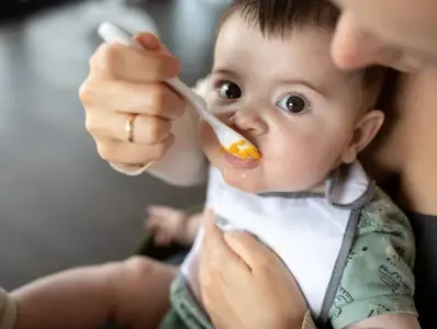 Omega-3 dla dzieci i niemowląt Dziecko karmione łyżeczką przez opiekuna